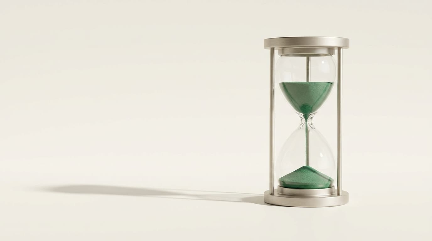 An hourglass with green sand, half run through